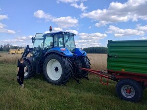 dziecko i traktor stoją na polu.
