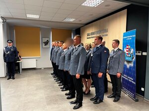 policjanci w mundurach wyjściowych stoją na sali konferencyjnej.