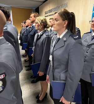 policjanci w wyjściowych mundurach znajdują się w sali konferencyjnej.