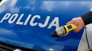 maska samochodu w niebieskim kolorze z napisem policja, urządzenie do badania stanu trzeźwości.