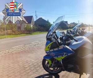 droga, obok stoi motocykl policyjny.