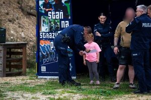 policjant i policjantka rozmawiają z dziewczynką, mężczyzna w krótkich spodenkach.